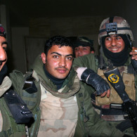 Iraqi soldiers celebrate after a raid in Fallujah